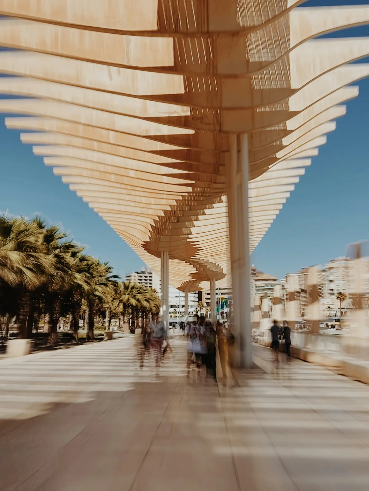 People walking under the Muelle Uno pergola in Malaga